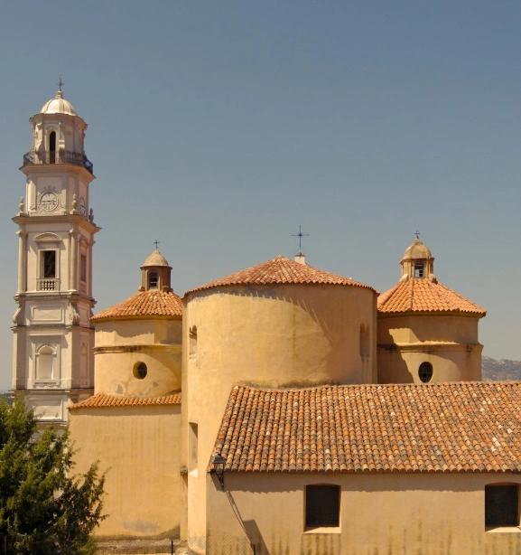 Église baroque jaune avec clocher à Calvi en Corse, architecture méditerranéenne